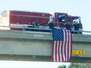 Flag hangs from overpass to honor Bo Taylor as his body is transported.