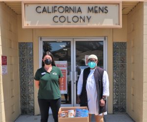 Man and woman with food drive box at California Men's Colony.