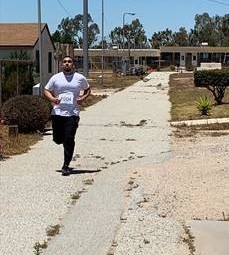 Man wearing a number runs at a prison facility.