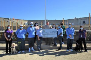 Sacramento prison residents and staff hold a check made out to Guide Dogs of America.