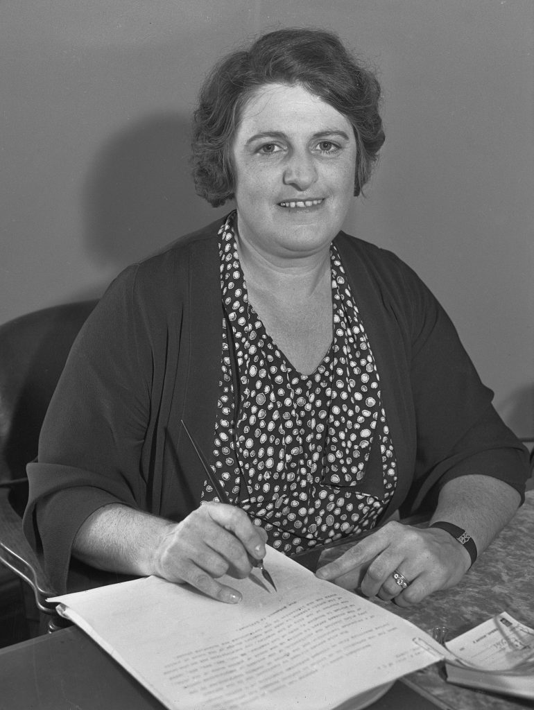 Claire Nordstrom parole officer in 1935 at Whittier as she looks over paperwork while sitting at a desk.