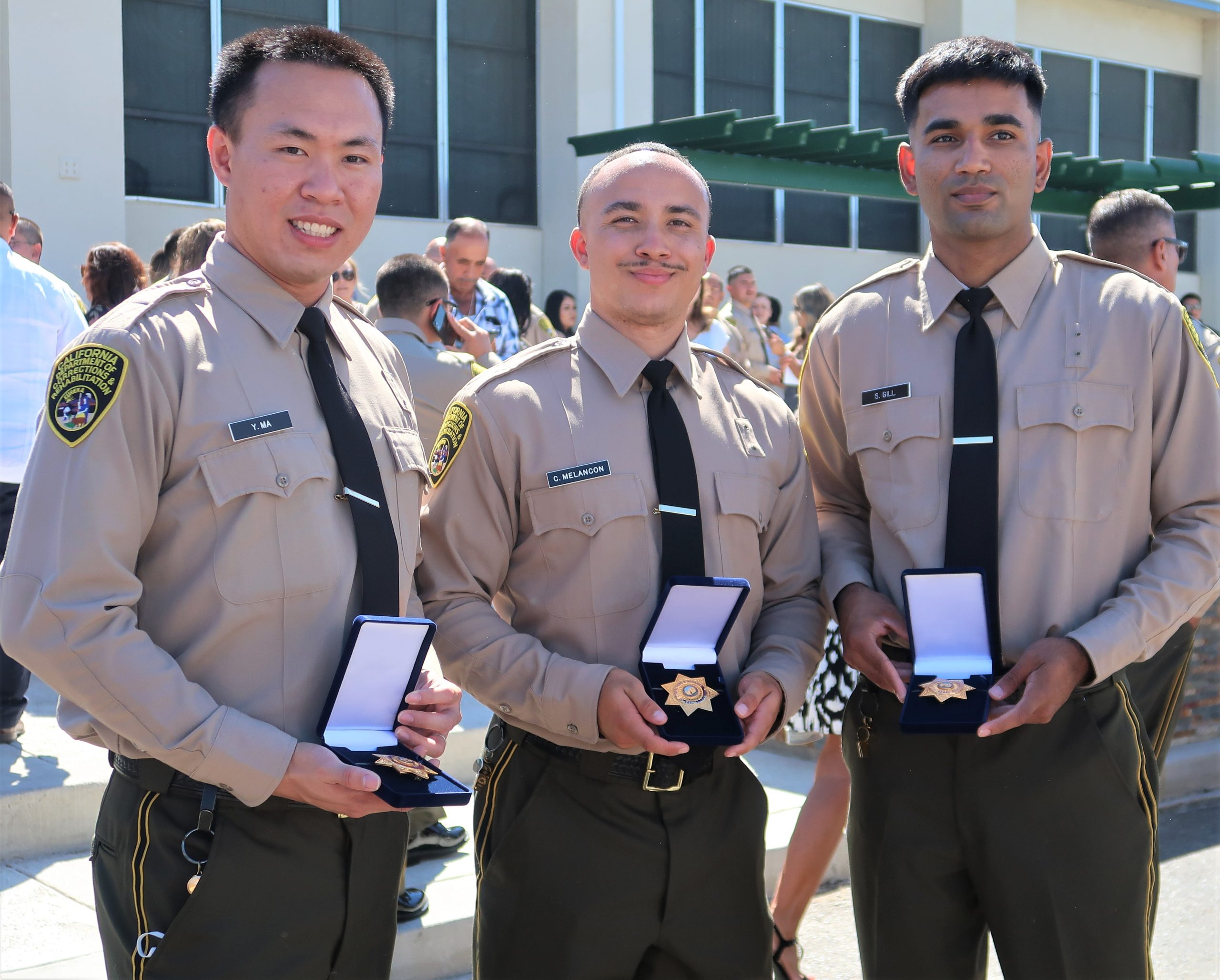 New correctional officers show their badges.