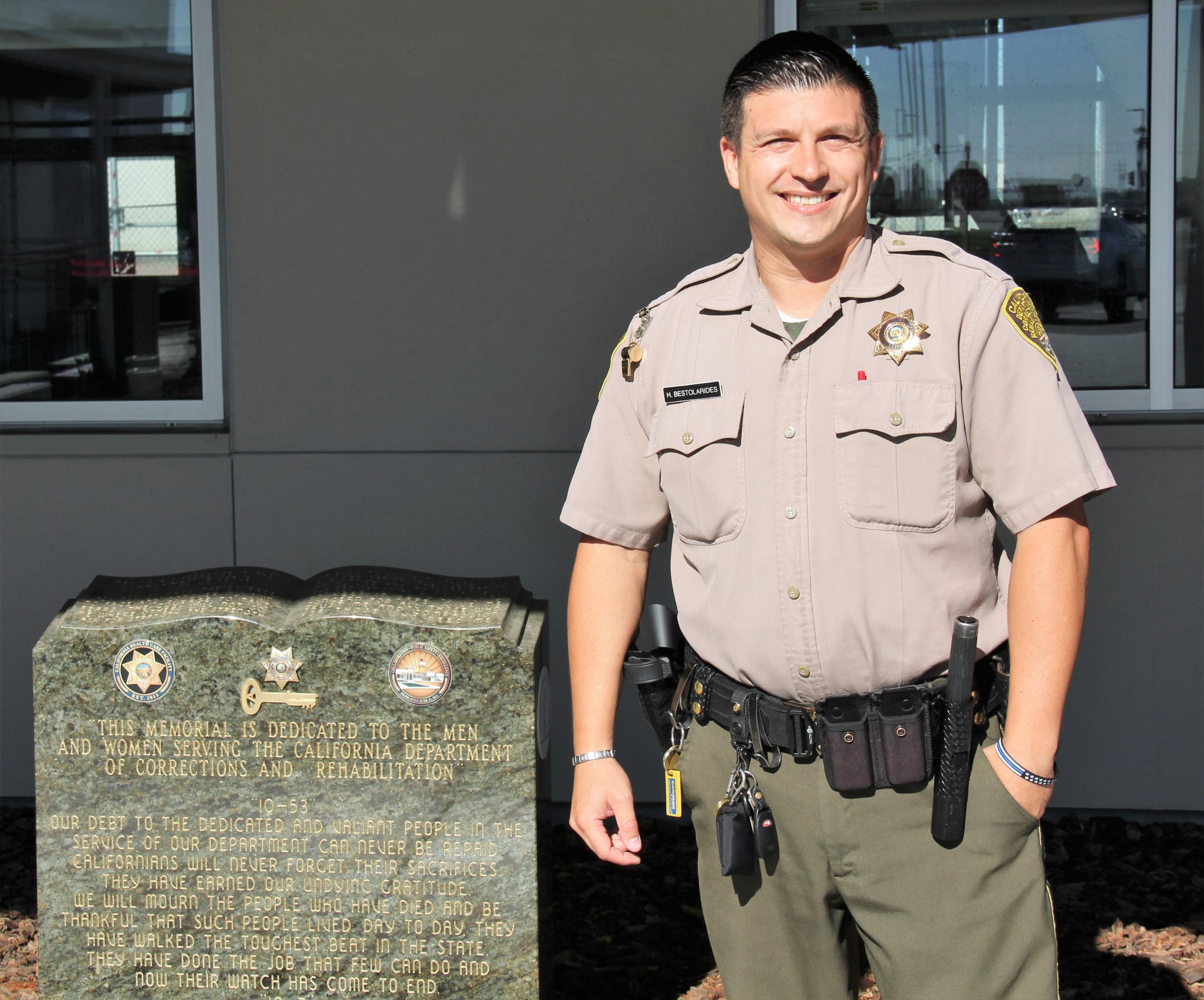 Correctional officer stands in front of California Health Care Facility.