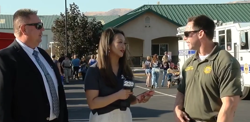 Two prison staff and a reporter at a community event.