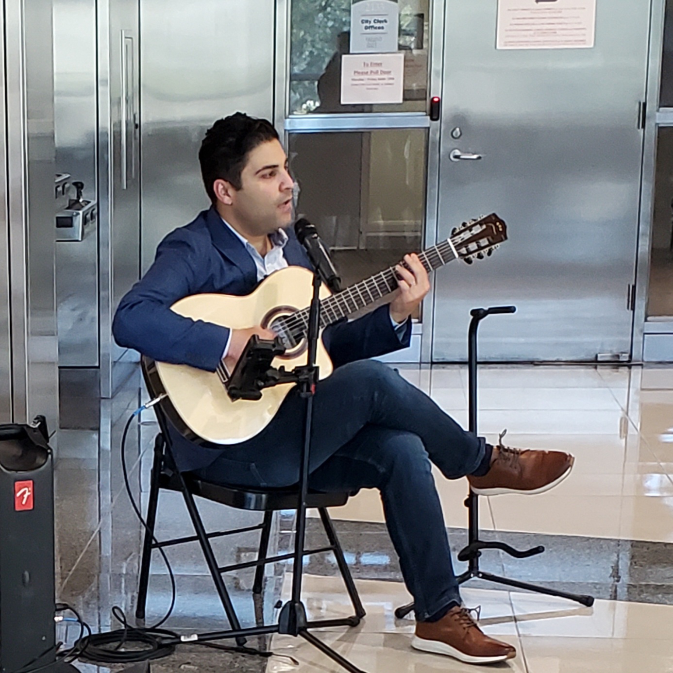 Man with guitar performs in Fresno City Hall Art Hop event.