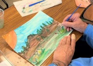 Avenal prison inmate paints with watercolors to accompany a haiku poem.