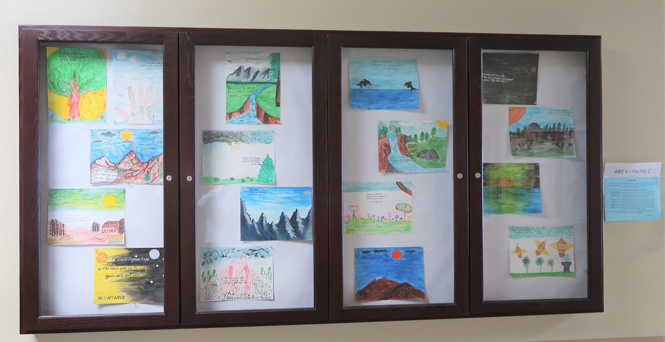 Haiku and watercolor paintings in a display case at Avenal prison.