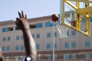 Basketball goes into net at San Quentin as referee holds up three fingers.