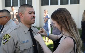 One of 185 cadets graduated as correctional officer has his badge pinned on his uniform.