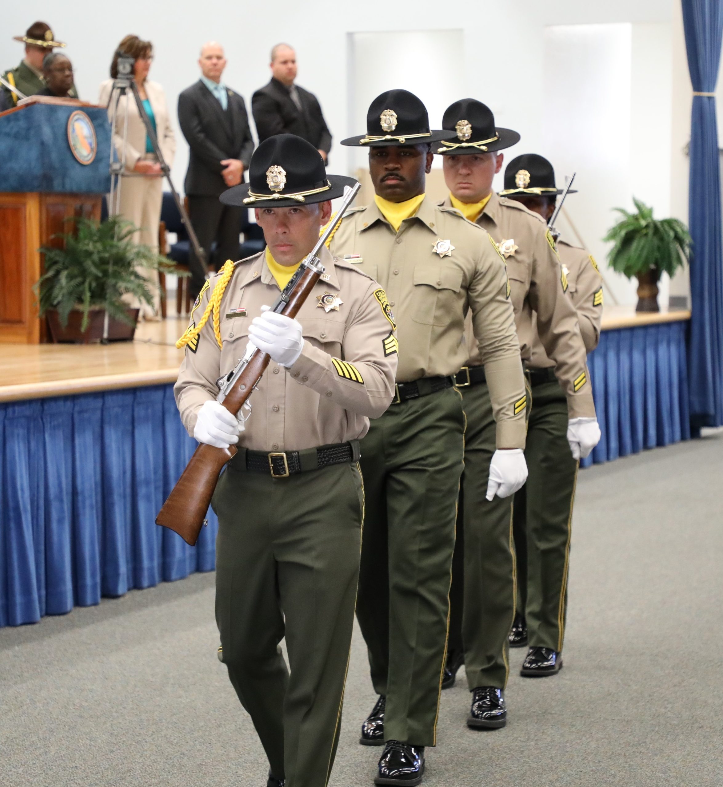 Four honor guard correctional sergeants walk into room.