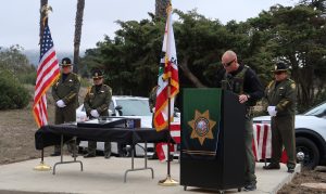 CMC K-9 Seger ceremony with lieutenant at lectern.
