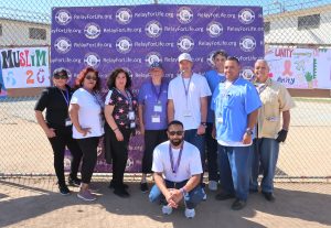 Relay for Life backdrop with men and women standing in front of it.
