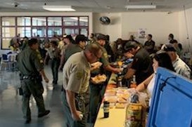 Prison staff line up for food.
