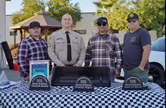 CDCR staff with plaques for a car show.