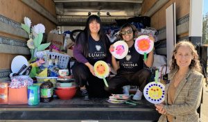 Three people and a moving truck filled with household supplies for Lumina Alliance.