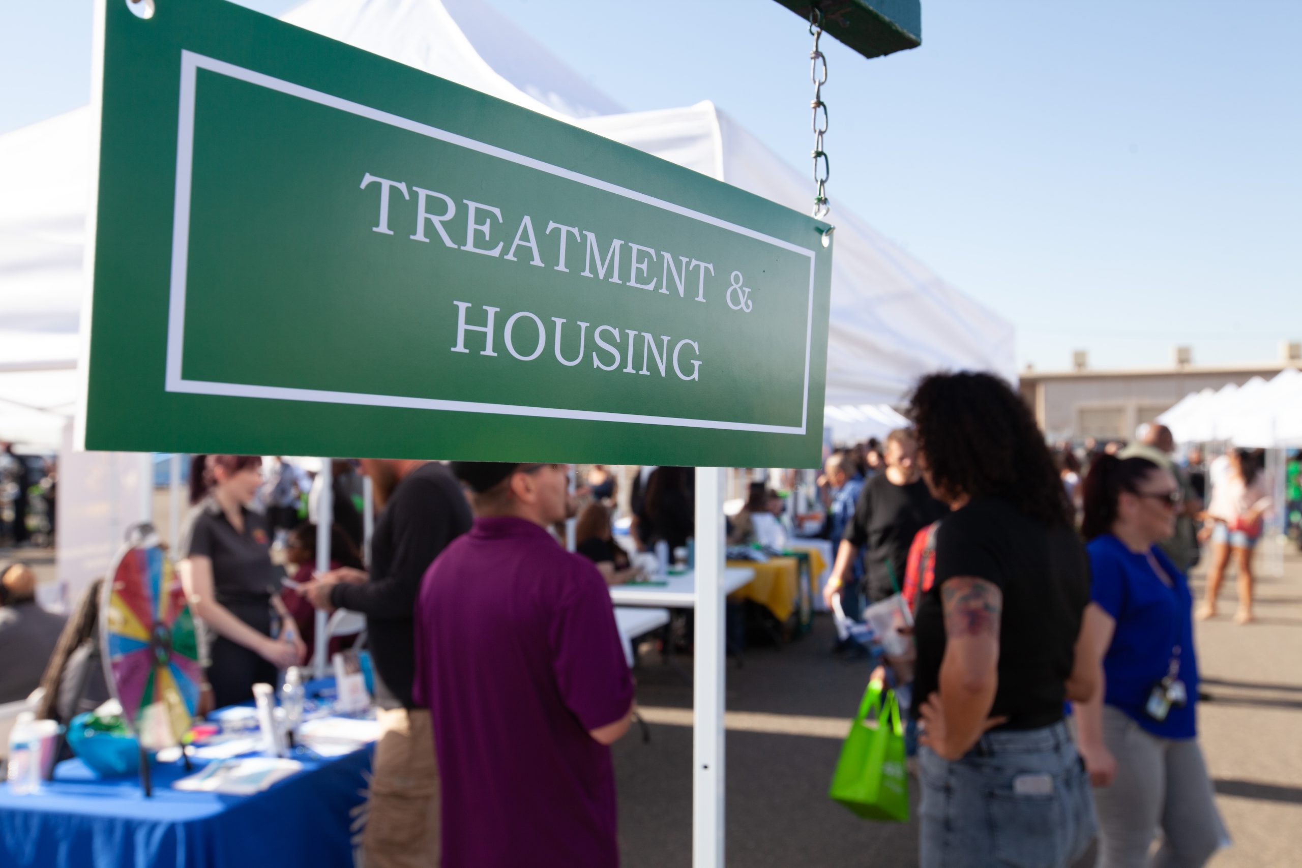 People on parole get help with "treatment and housing" according to a sign hanging from a reentry fair booth.