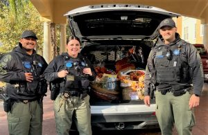 CDCR officers with a trunk full of Thanksgiving baskets.