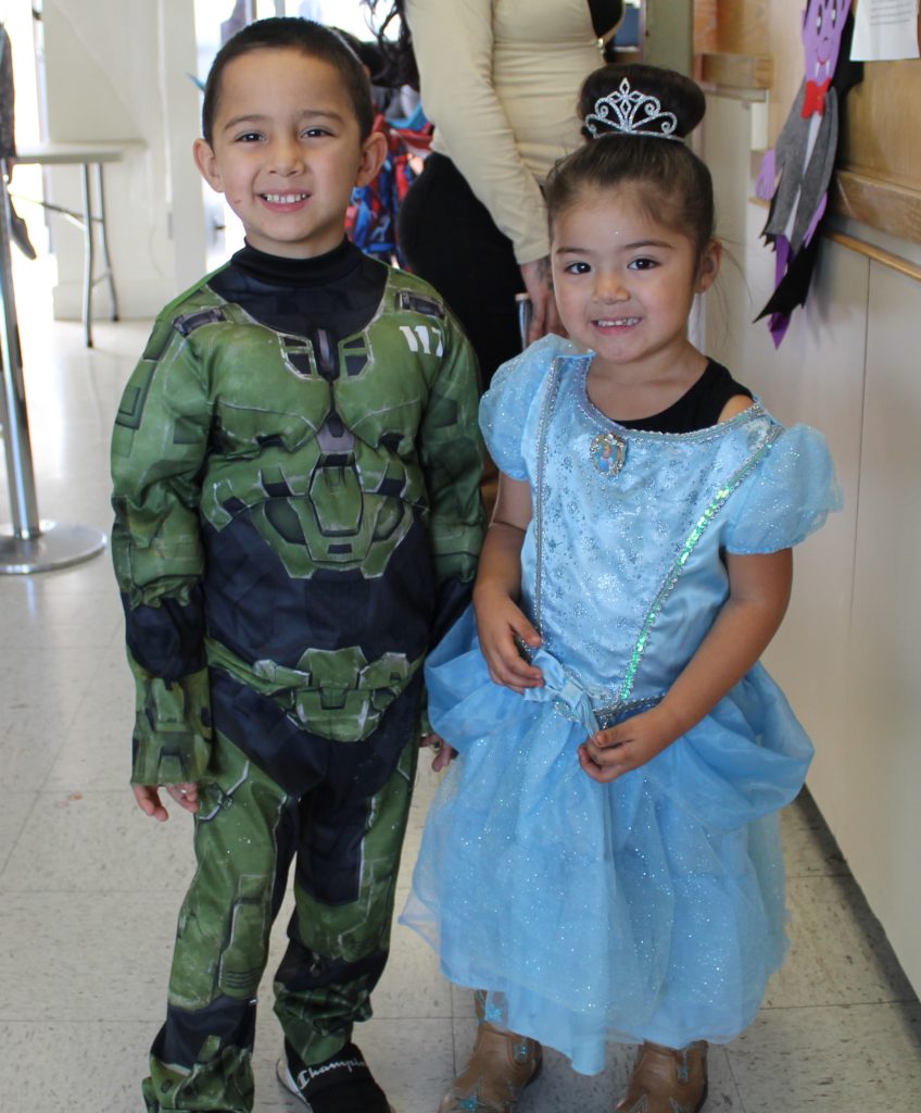 Two costume-wearing kids in a visiting room at PVSP.