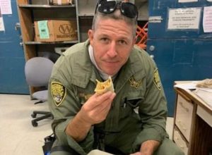 CDCR officer Donny Tillery in uniform eating a breakfast burrito.
