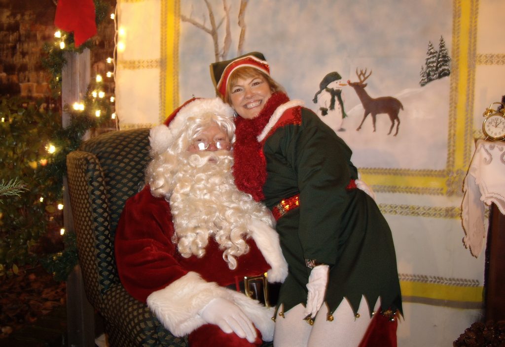 A volunteer Santa and elf with a photo backdrop.
