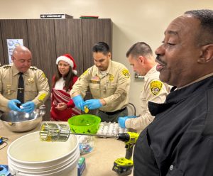 Five prison staff crack open eggs to make breakfast.
