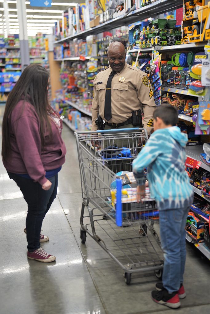 Man in CDCR uniform with another woman and a child in a store.