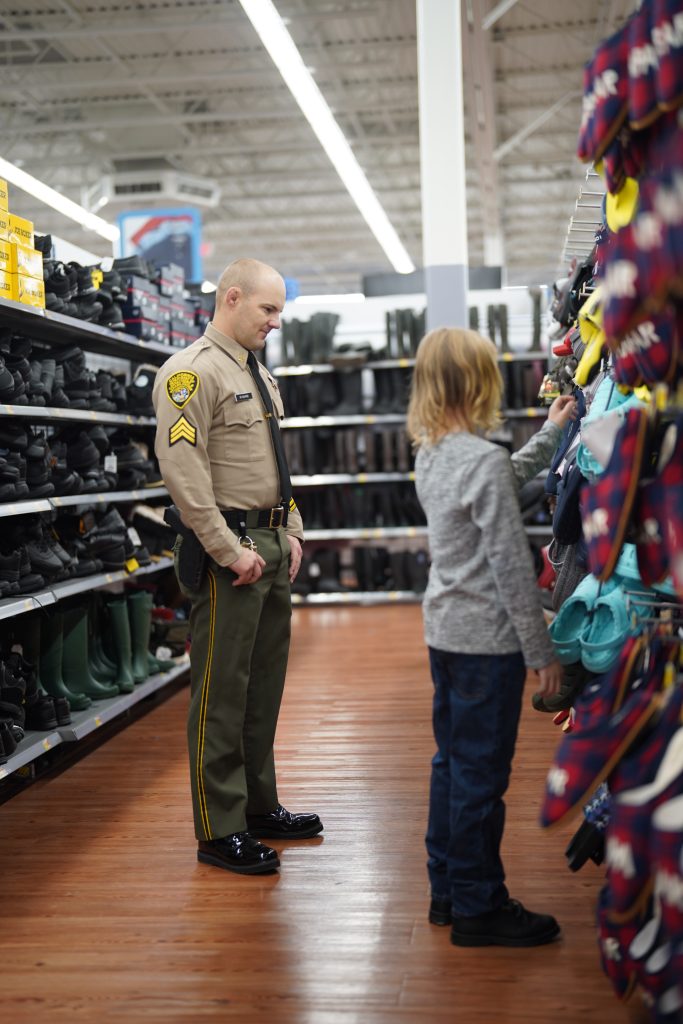 Training Center staff sergeant and child in a shoe aisle.