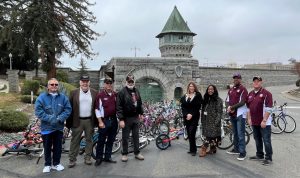Prison staff and Rotary Club members with refurbished bikes in front of Folsom Prison.