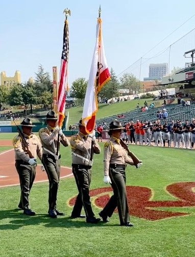 CDCR honor guard marches at baseball game Sept. 11 tribute.