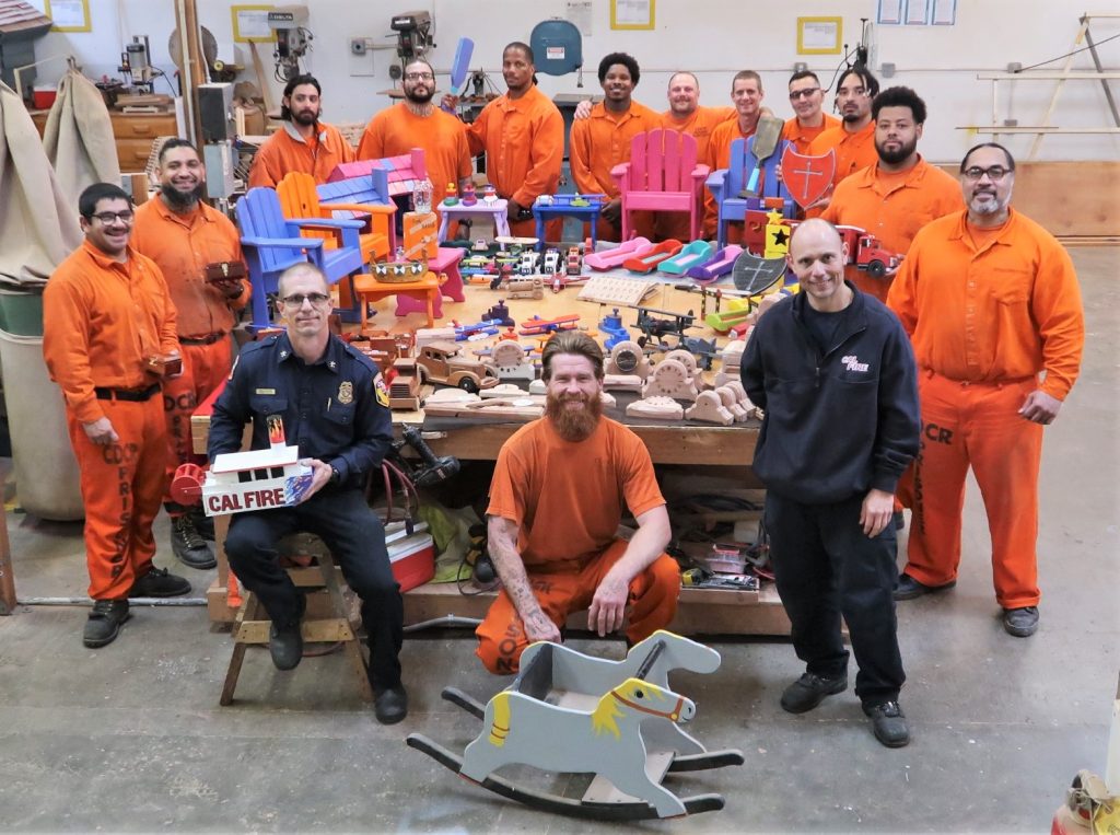 Incarcerated firefighters, two CAL FIRE staff and a table full of wooden toys.