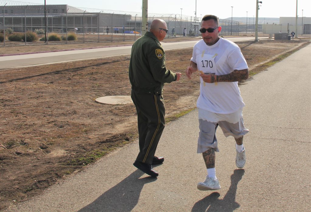 An incarcerated runner and a correctional officer at a CHCF fundraiser for local children.