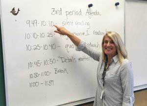 Woman at a whiteboard in a classroom.