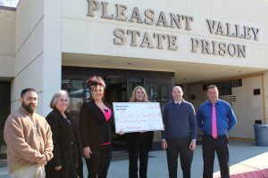 Pleasant Valley State Prison staff present a check to a cancer research foundation.