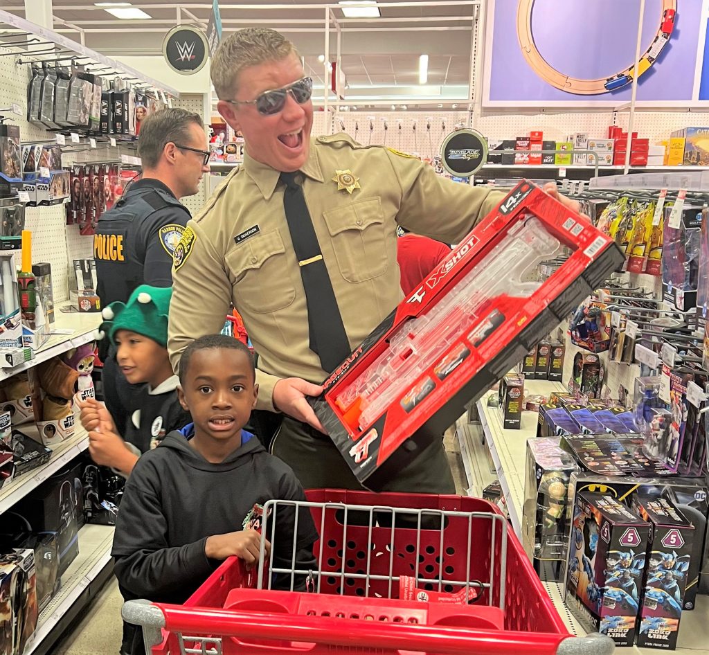 Correctional officer and a child shopping for gifts.