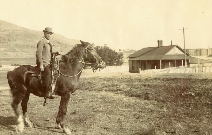 Prison member on a horse near San Quentin in early 1900s. A building can be seen in the background.