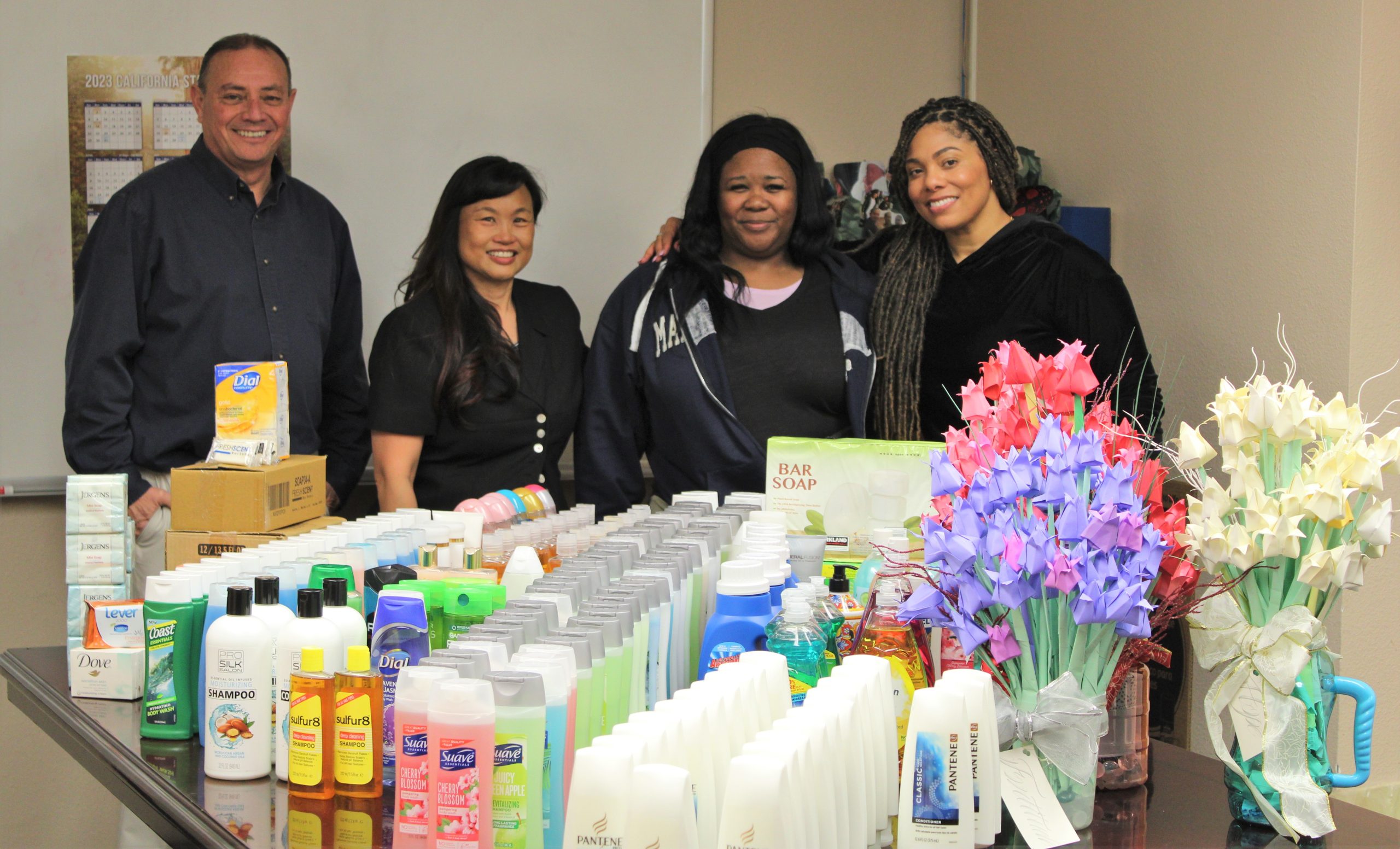 Restorative justice effort at Division of Juvenile Justice (DJJ) shows staff with a table full of different soap products to donate to women and children in need.