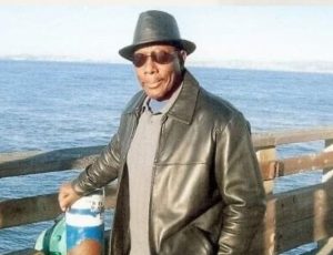Ocean in background with Alvin McDaniel standing on a pier.