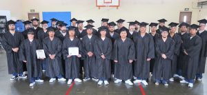 Incarcerated graduates wearing caps and gowns.