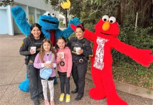 Parole agents with children, Cookie Monster and Elmo.