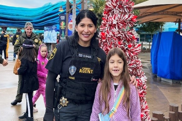A parole agent and a child with holiday decorations behind them.