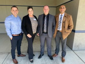 Four Valley State Prison employees in plain clothing stand shoulder-to-shoulder.