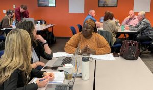 People at tables during a meeting.