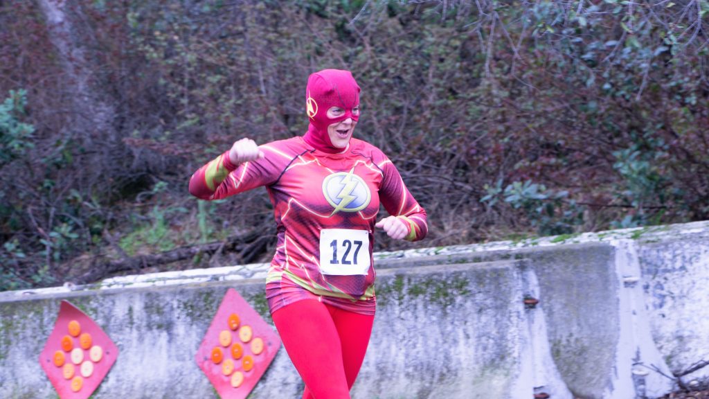 Man running while wearing a Flash costume.