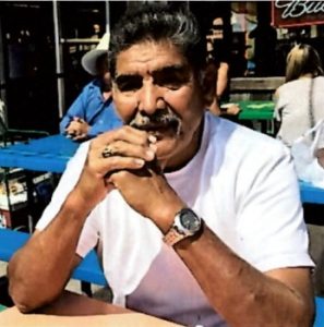 Sitting with arms clasped in front of him is Rogelio Baez, Sr.