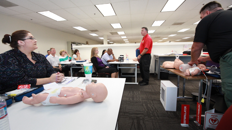 An instructor in front of a class to teach CPR.
