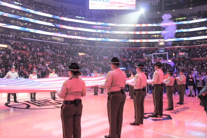 CDCR honor guard holds large flag at a Clippers game.
