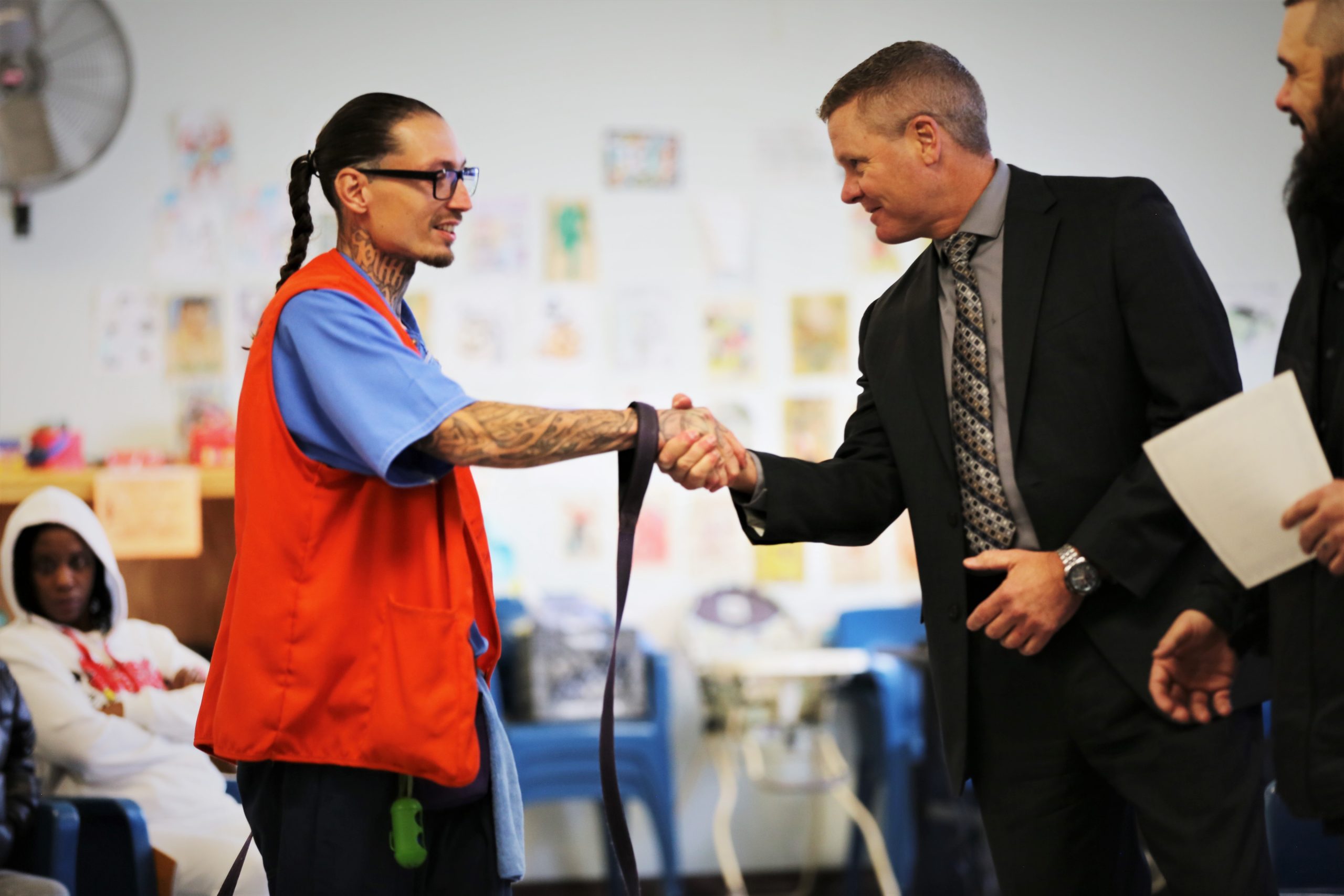 ARC graduation at Mule Creek State Prison with a graduate and chief deputy warden shaking his hand.