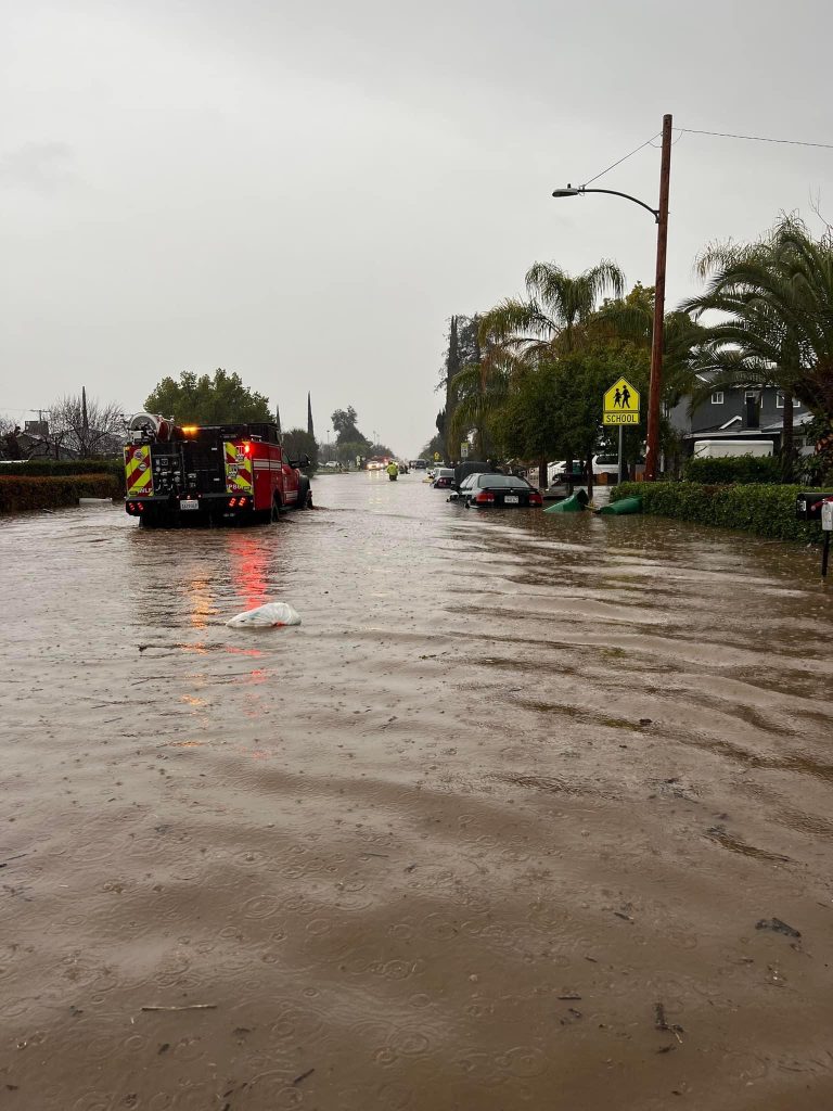 A fire truck makes it way through a flooded street