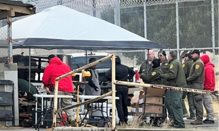 Prison staff wait in line at a barbecue.
