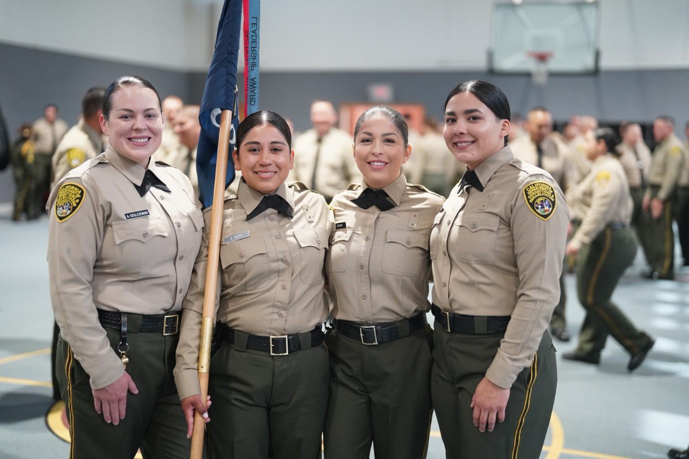 Four female correctional officer cadets prepare to graduate the academy.